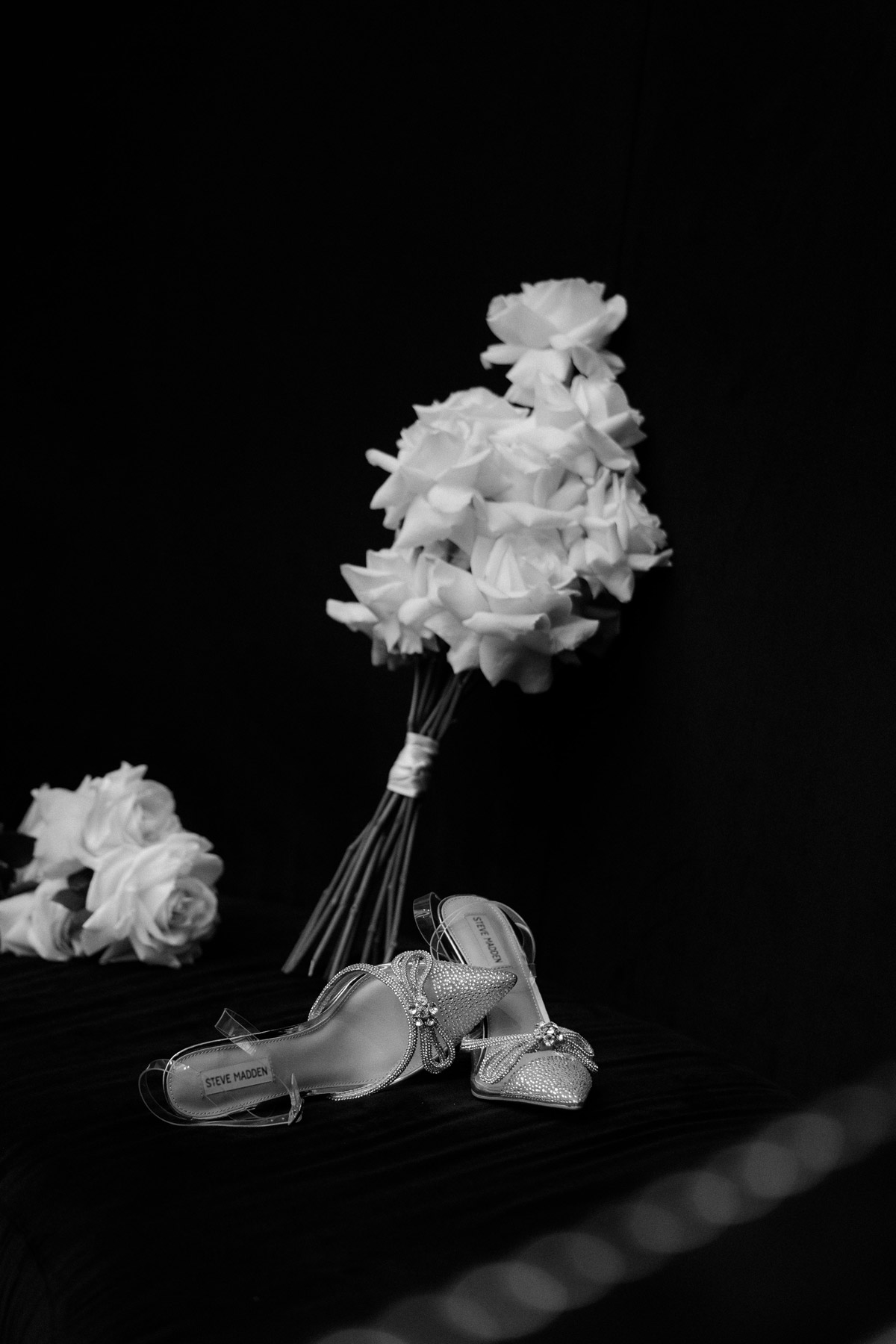Steve Madden Brautschuhe mit Glitzer und Schleife kreativ mit Brautstrauß aus weißen Rosen kombiniert