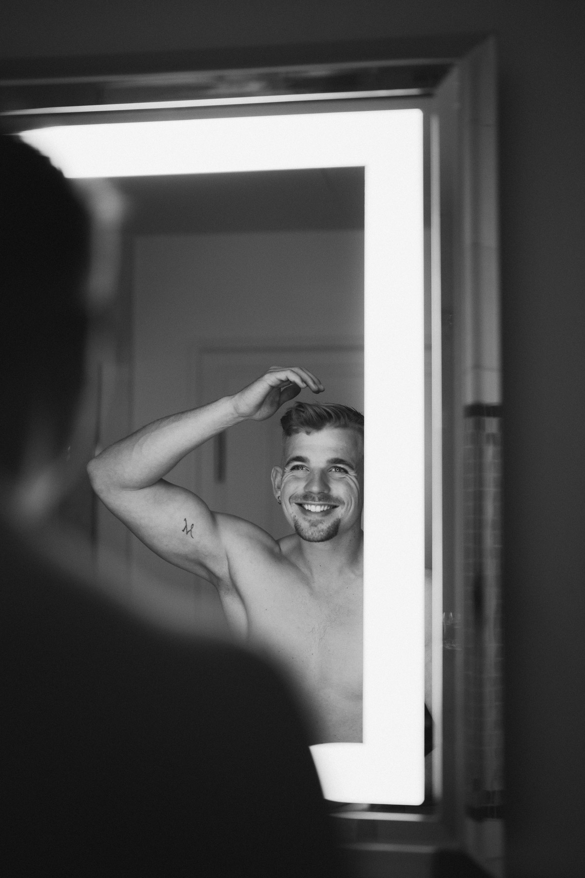 Bräutigam steht vor Spiegel in der Hotel de Rome Suite