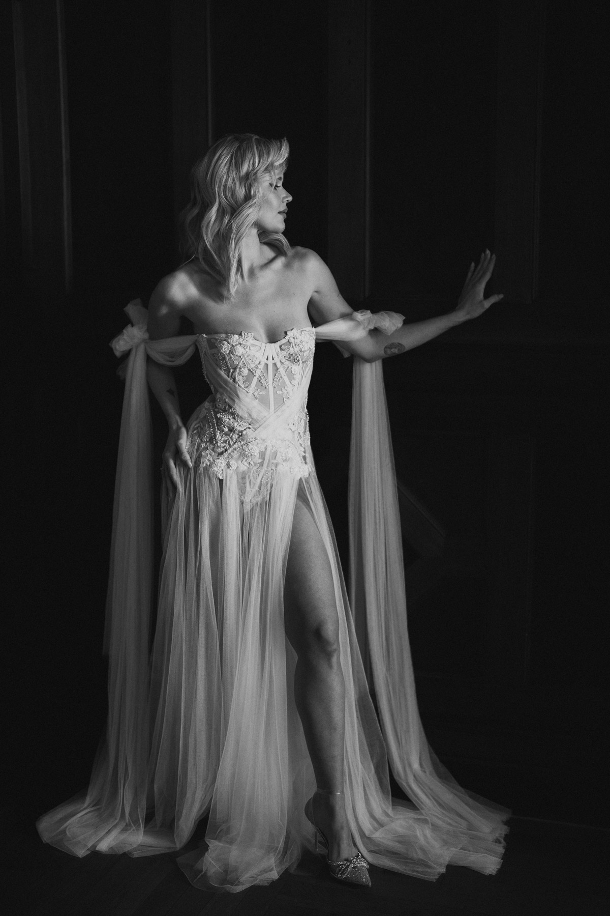 Braut Boudoir Ganzkörperpose mit Arm lässig in Hüfte gestützt für sinnliche Taillie in Schwarz-Weiß