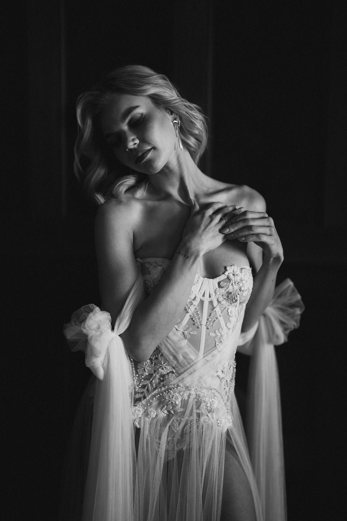 Sinnliches Brautportrait in Schwarz-Weiß mit Fokus auf das Kleid, moderne Hochzeitsfotografin Berlin Melanie Meißner liefert Idee für sinnliches Posing durch leichtes Zurückwerfens des Kopfes mit geschlossenen Augen