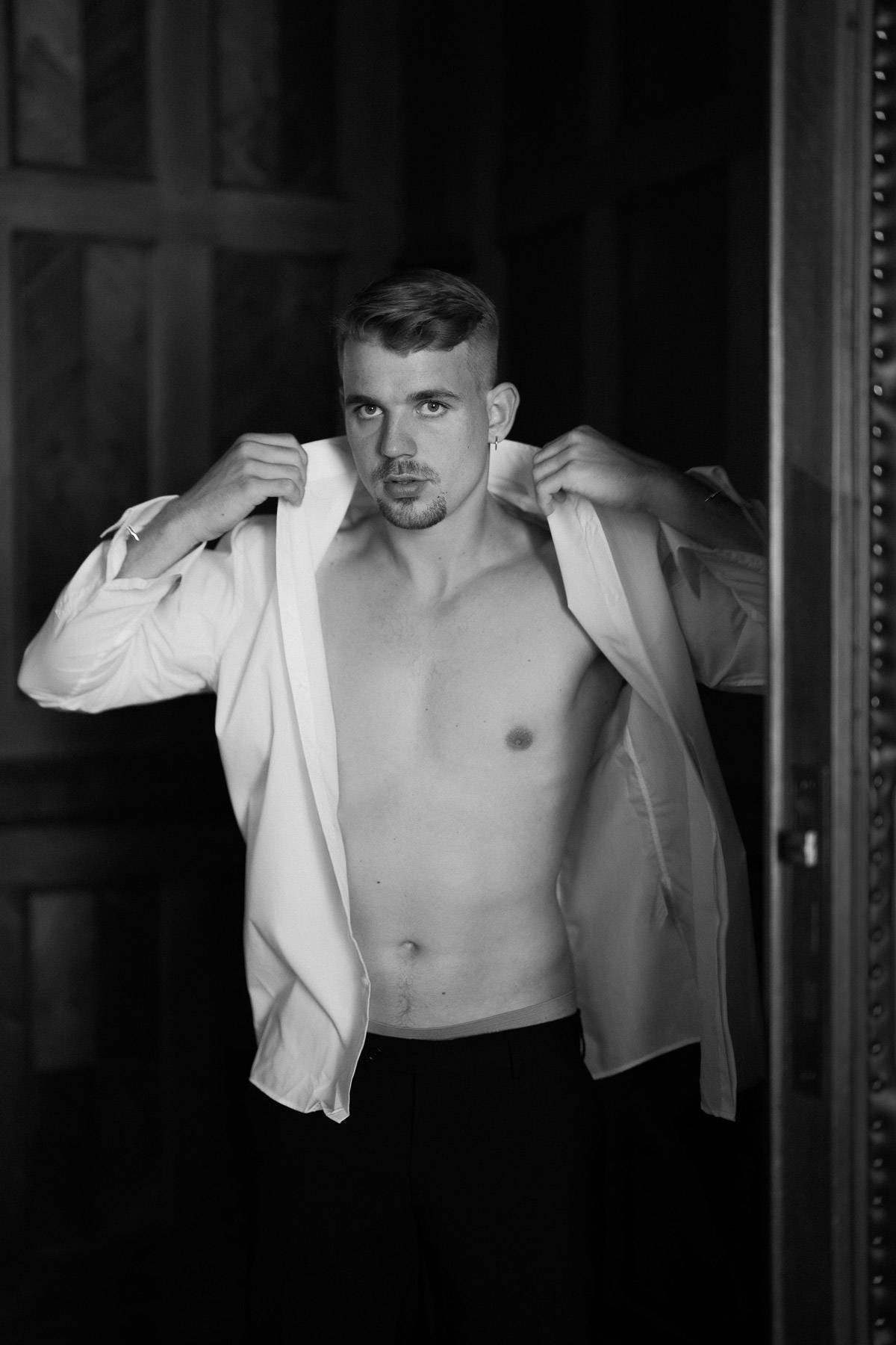 Bräutigam zieht Hemd an mit offenem Kragen, fashion-inspiriertes Männerportrait von Melanie Meißner