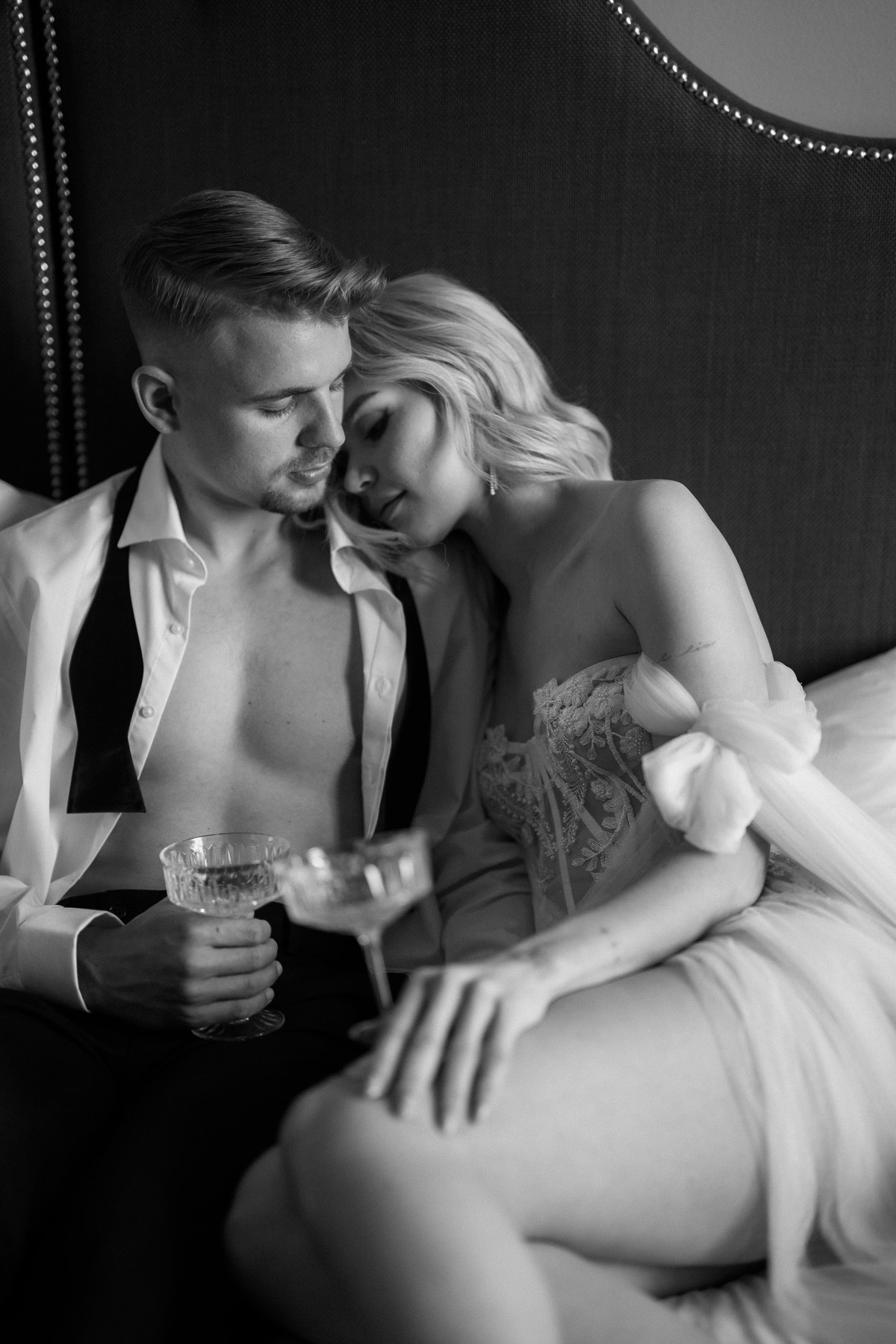 Weddingcouple Boudoir Idee auf dem Bett schmusen und Champagner trinken während des Getting Readys am Hochzeitsmorgen