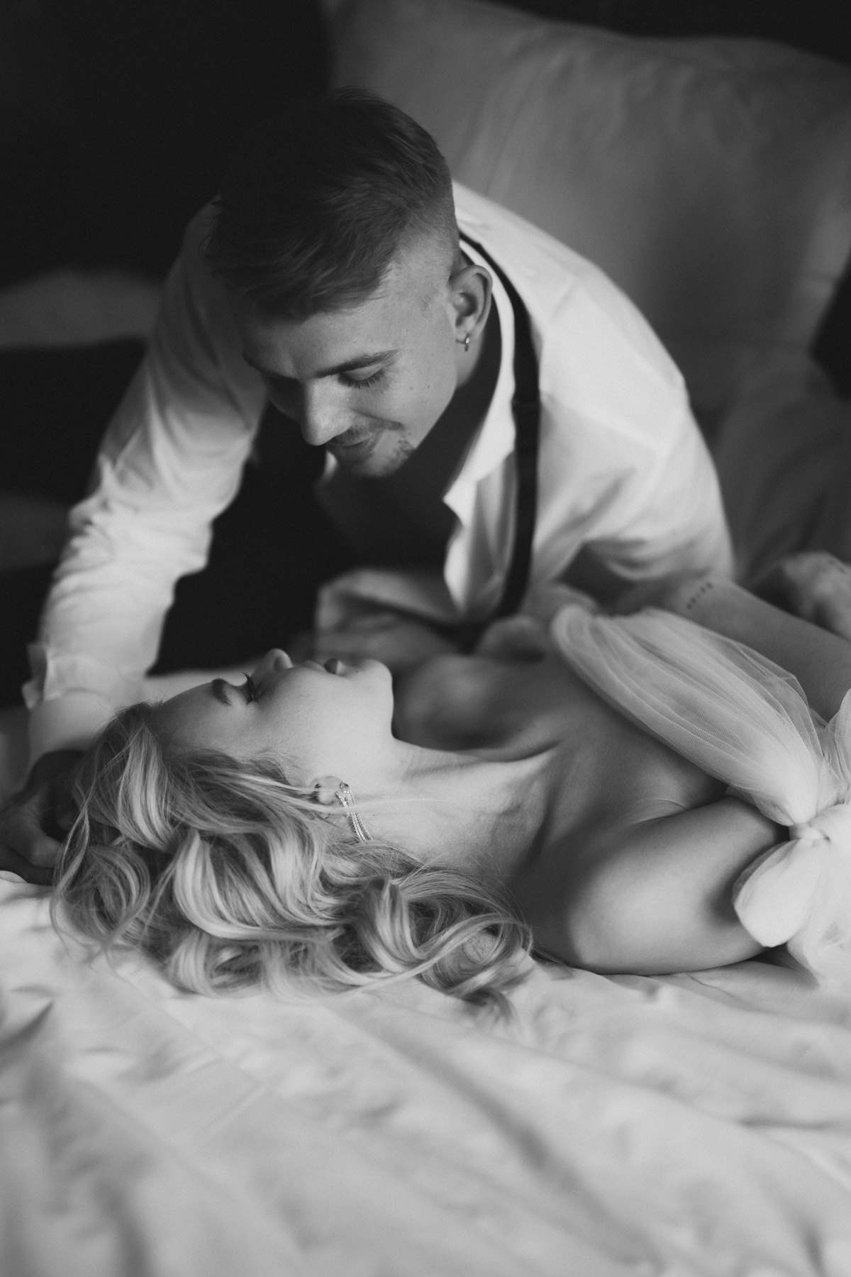 sinnliche und intime Hochzeitsfotos am Morgen Bräutigam beugt sich über die Braut