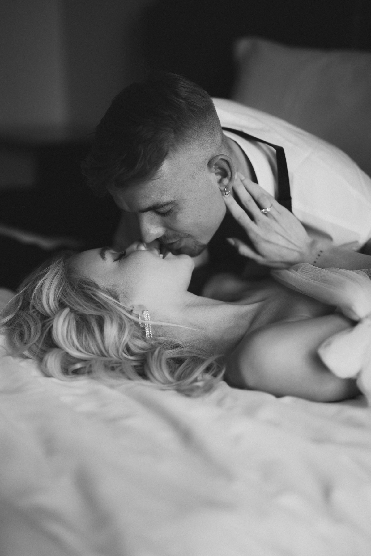 Braut greift am Hals vom Bräutigam in Schwarz-Weiß