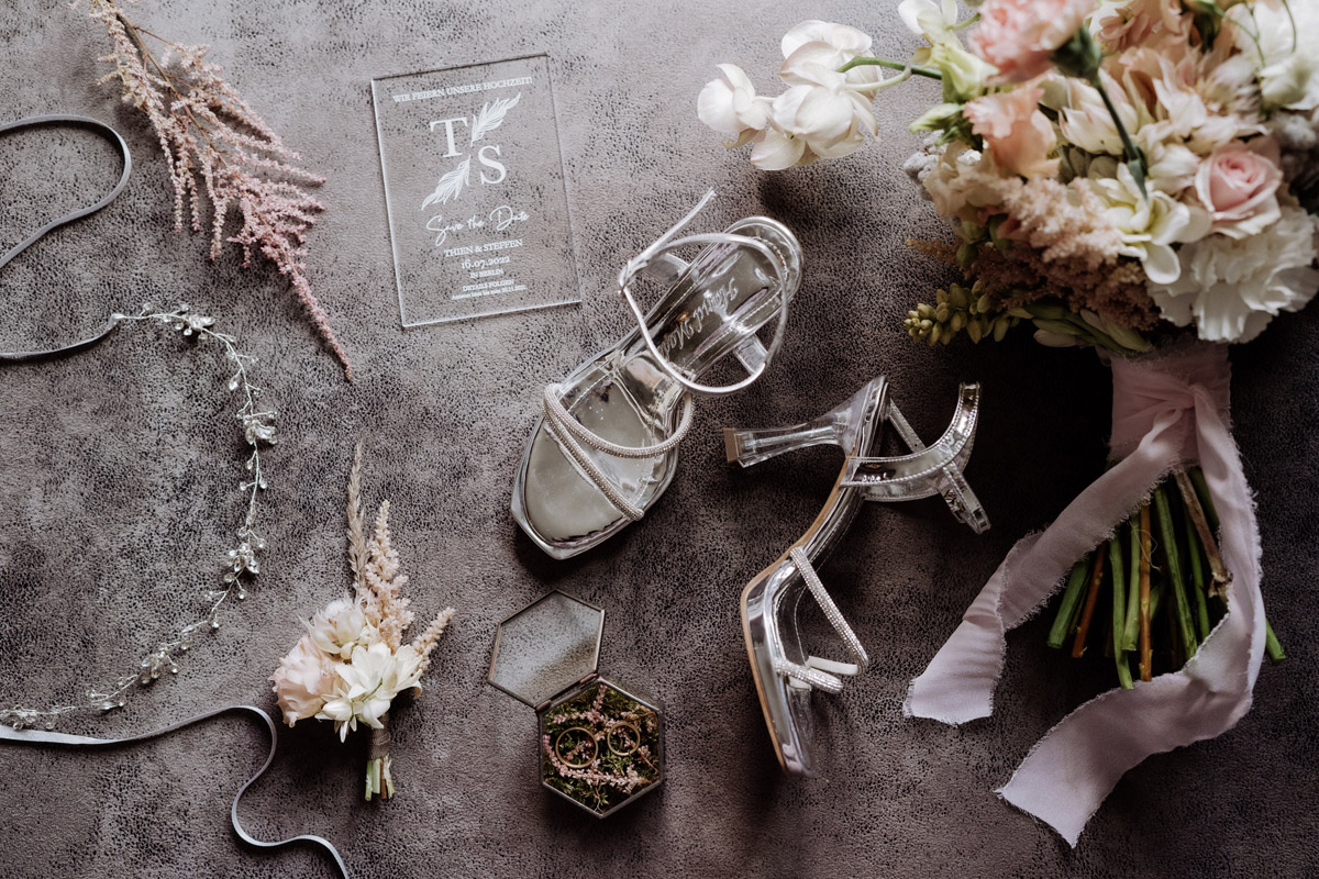 Flat Lay: Brautschuhe, Hochzeitsblumen und Einladung zur Restaurant Garten Hochzeit Berlin Mitte
