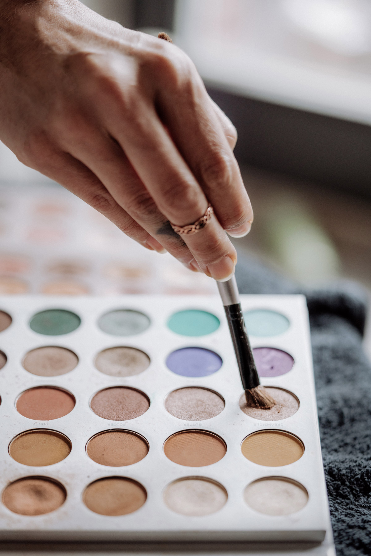 Reportage Schminkpinsel wird in Farbe getaucht