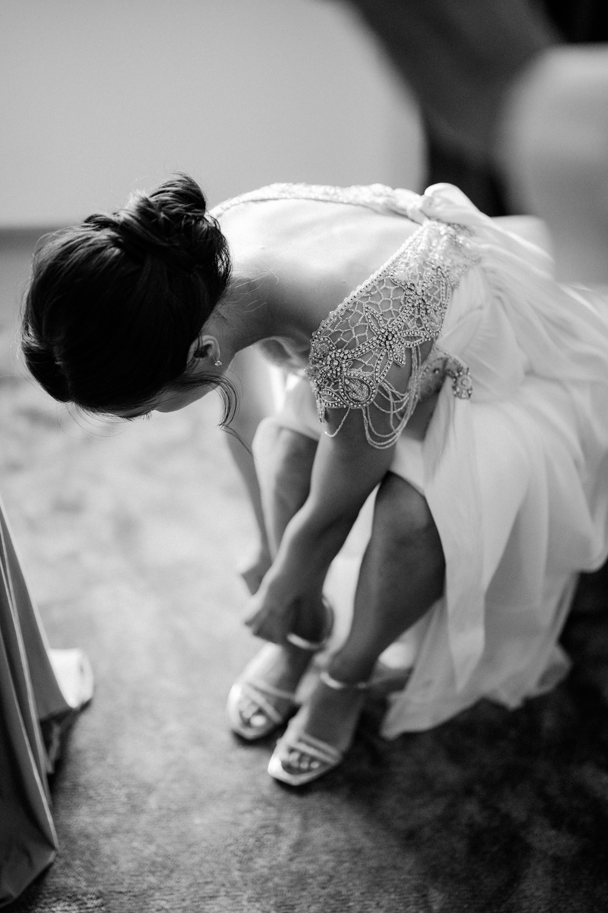 Detailaufnahme Hochzeitskleid beim Schuhe anziehen der Braut