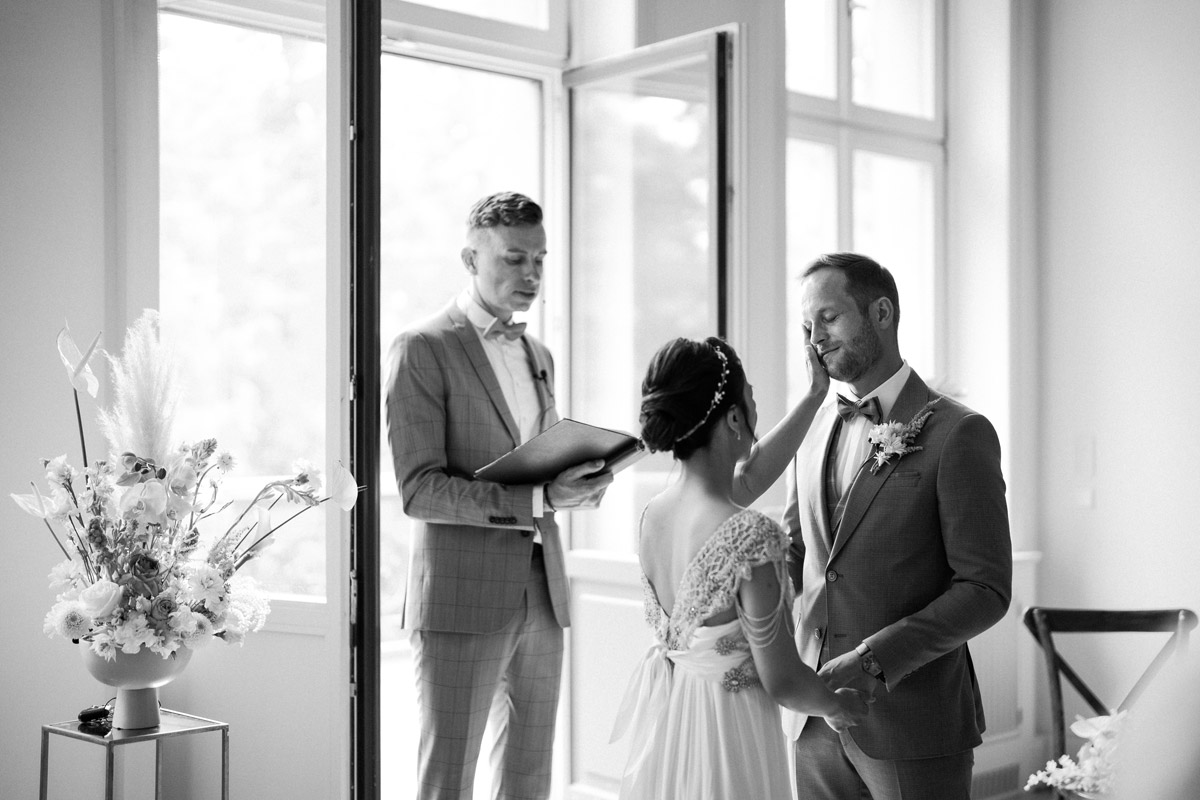 emotionale Hochzeitsreportage Berlin: Braut tröstet weinenden Bräutigam bei freier Trauung im Schloss Biesdorf