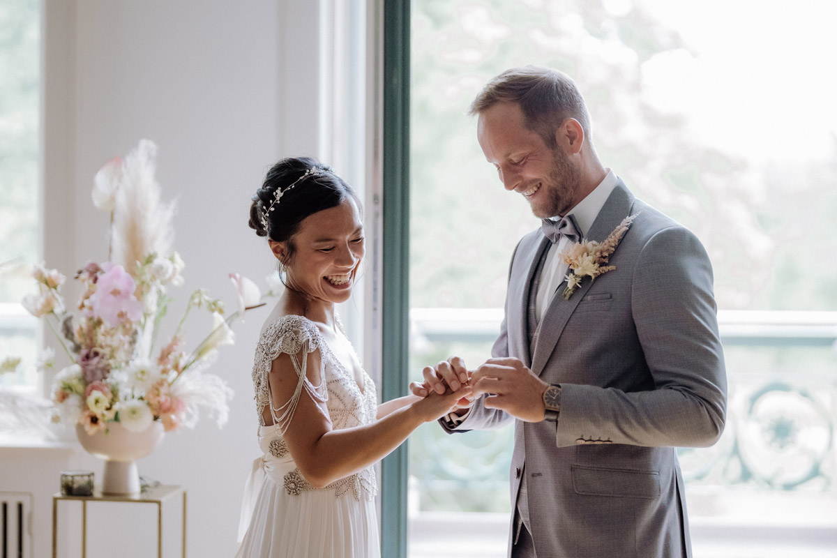 Hochzeit im Schloss Biesdorf Berlin: Braut bekommt vom Bräutigam Ehering aufgesteckt
