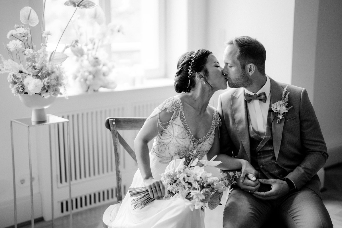 Hochzeit Schloss Biesdorf Berlin in Schwarz-Weiß: Brautpaar küsst sich