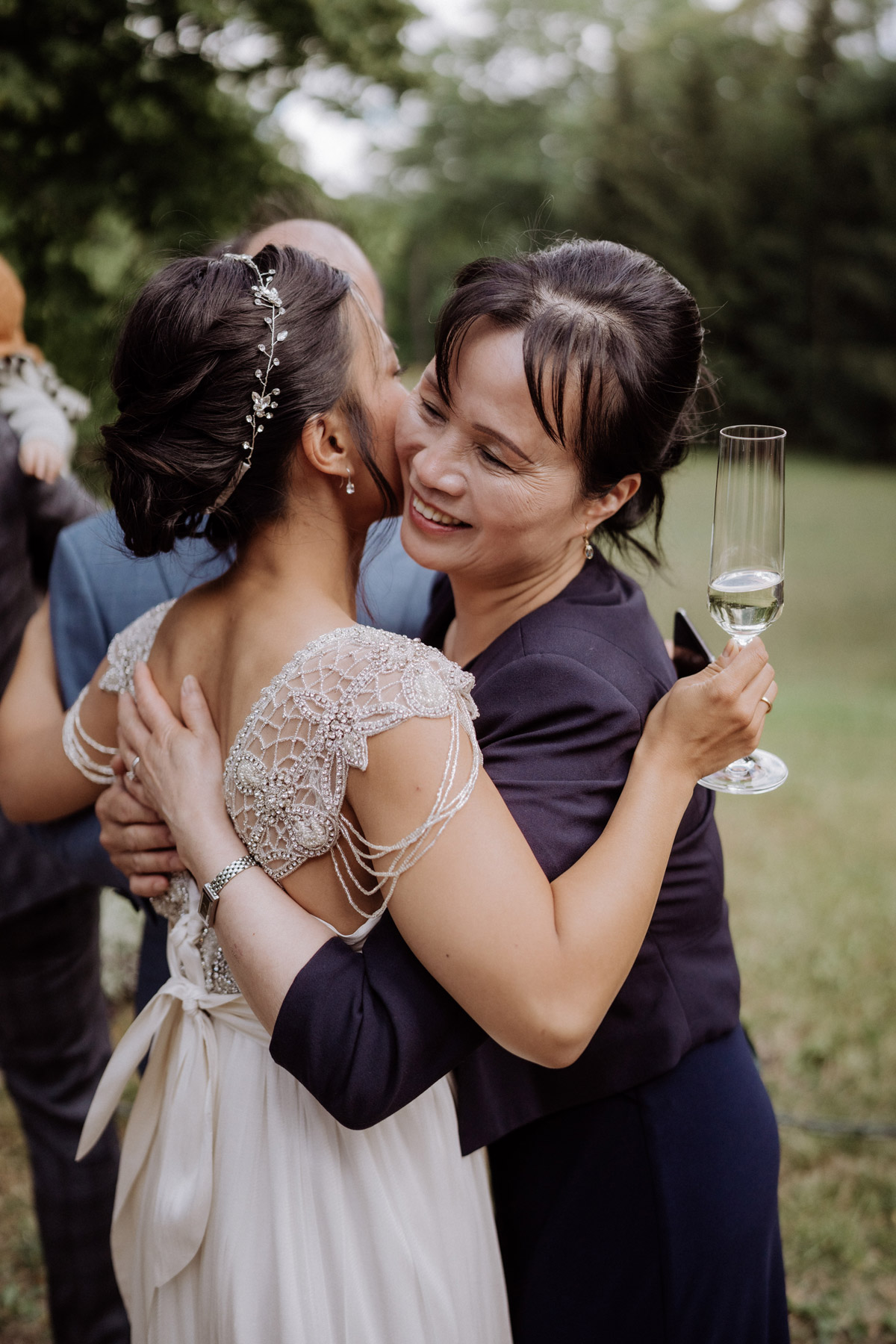 Brautmutter gratuliert Braut bei Sektempfang