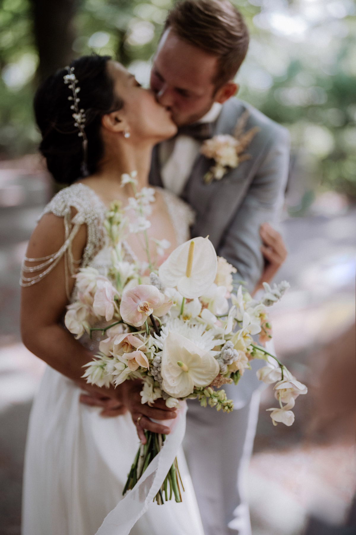 Brautstrauß wanna marry Berlin mit unscharfem sich küssendem Paar im Schlosspark