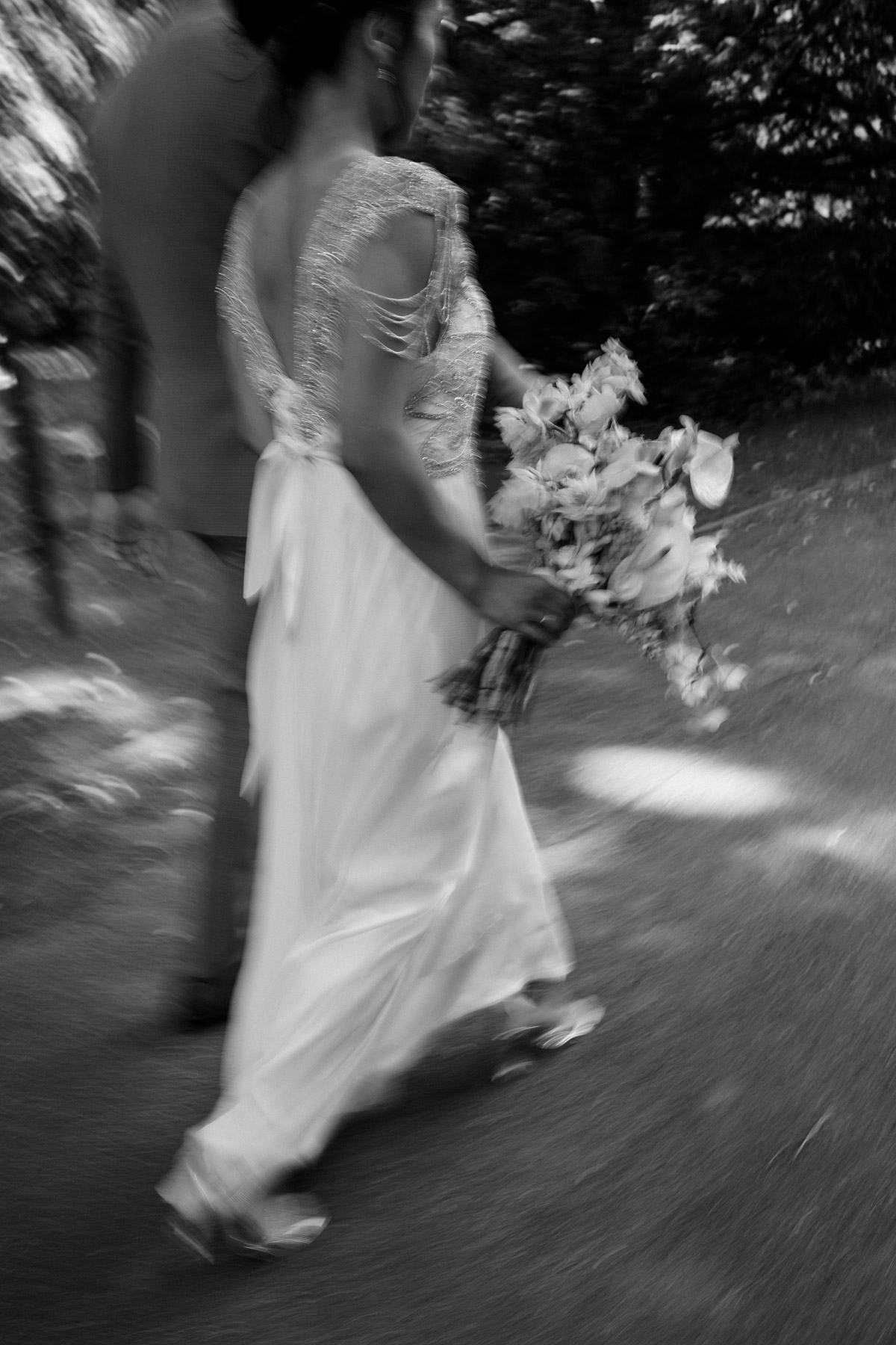 Künstlerisches Hochzeitsfoto mit Motion Blur: Brautpaar läuft dynamisch durch den Park Schloss Biesdorf – Editorial Hochzeitsfotografie Berlin