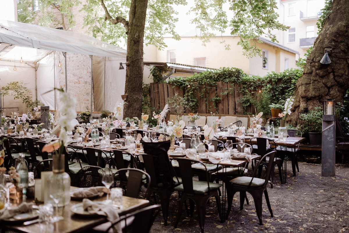 heimlichTreu Berlin Hochzeit im Hinterhof Garten stehen Tische