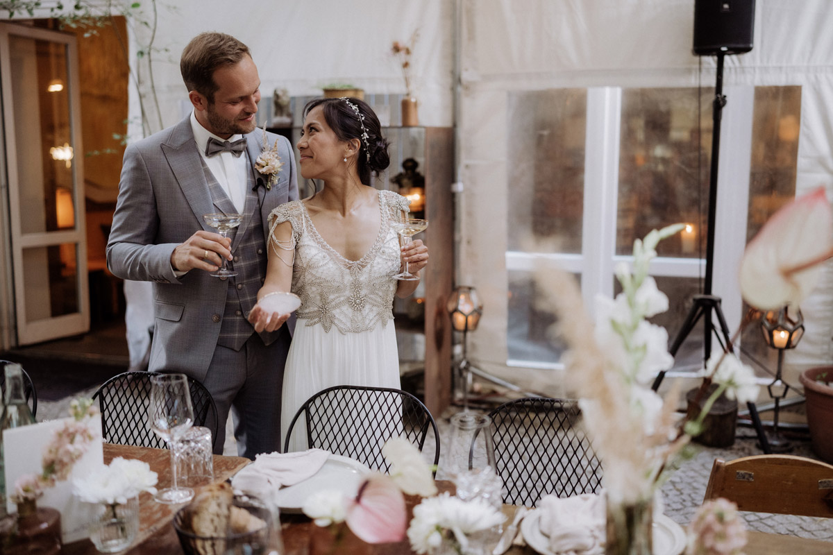 Brautpaar steht vor Hochzeitstisch im heimlichTreu Berlin