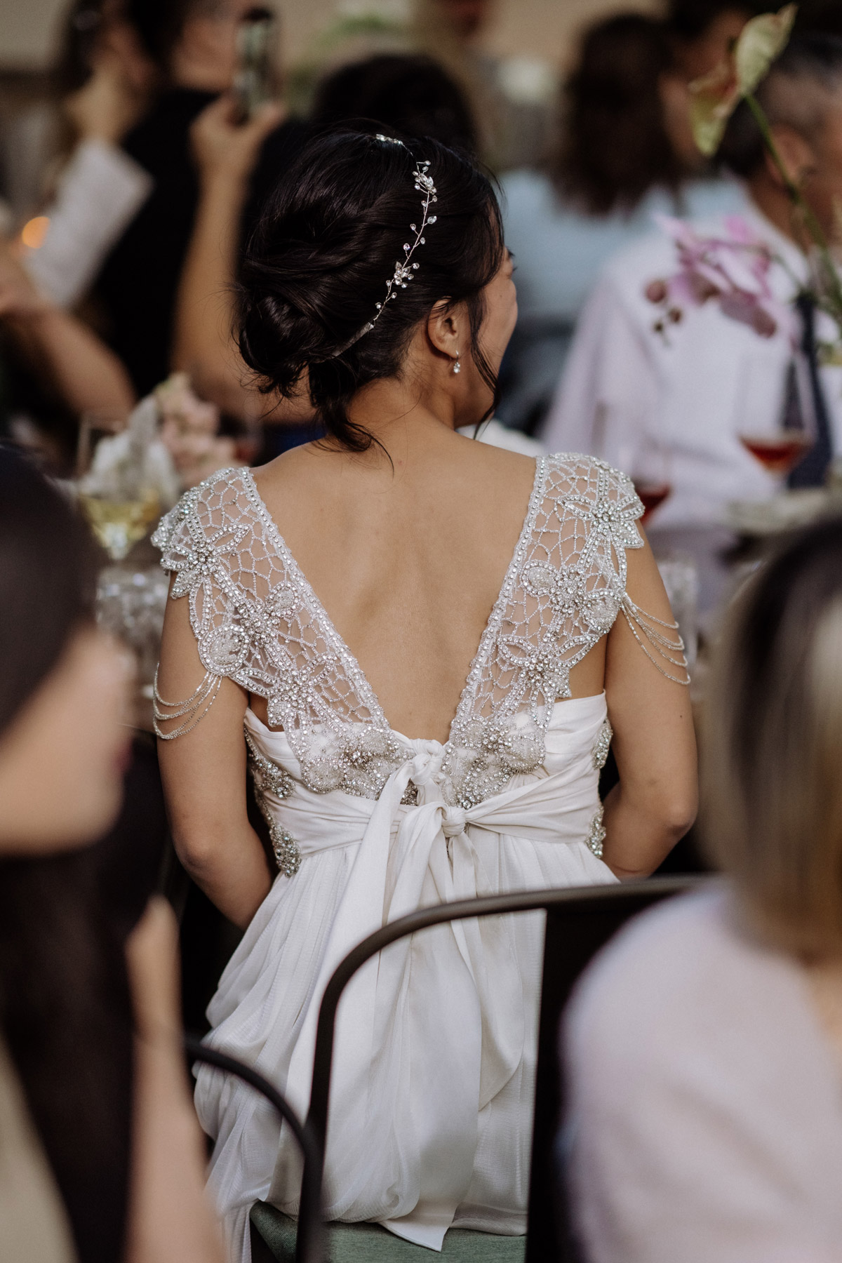 Braut im Second Hand Hochzeitskleid von hinten sitzt am Tisch