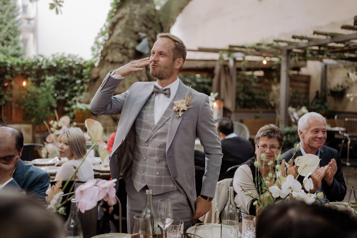 Bräutigam wirft Kusshand zur Braut im Hinterhof heimlichTreu Berlin Restaurant