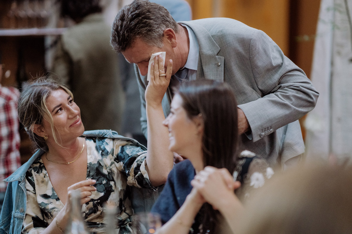 emotionaler Hochzeitsmoment: Hochzeitsgast wischt Tränen von anderem Gast weg