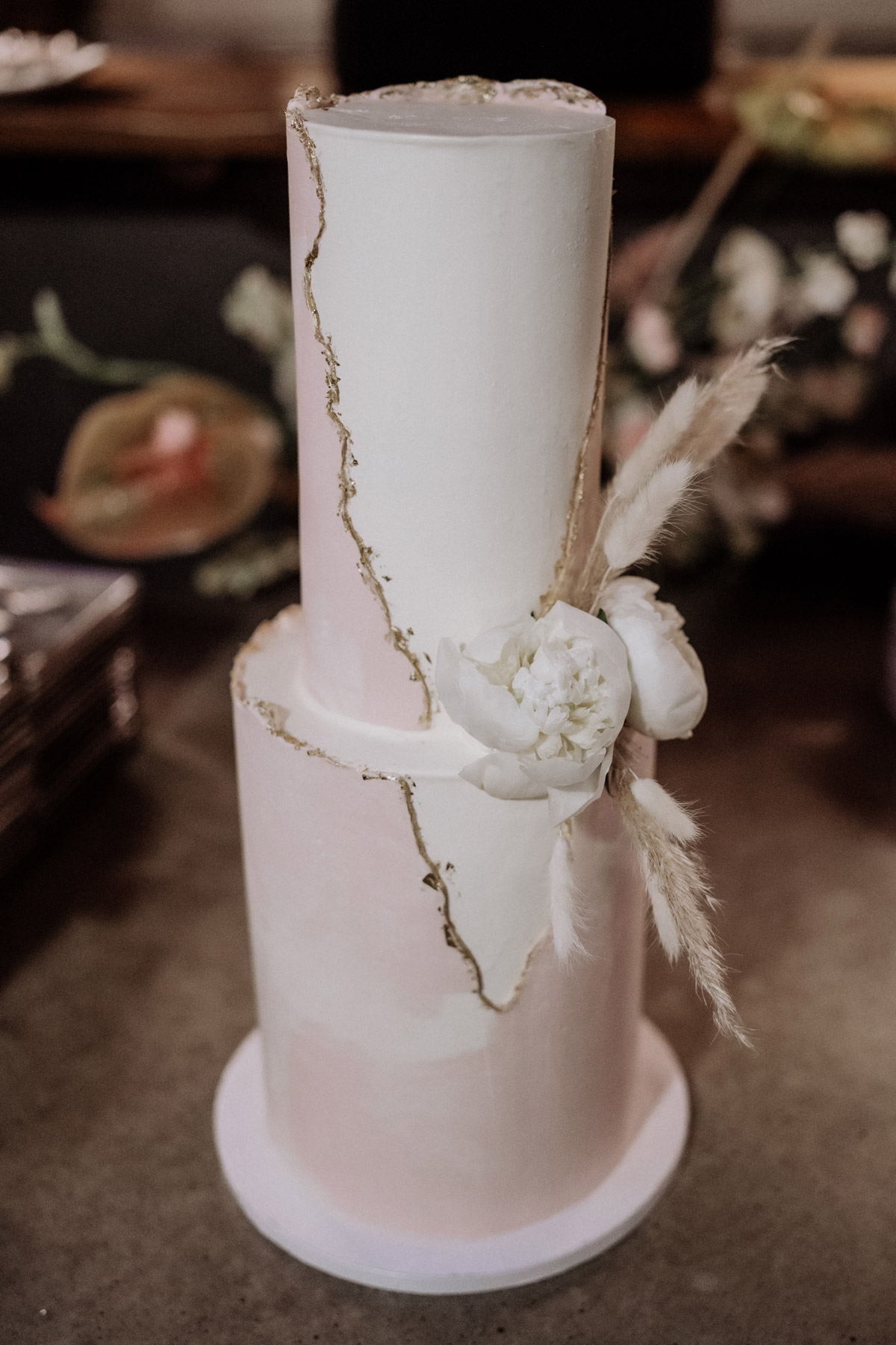 zweifarbige und zweistöckige Hochzeitstorte in Weiß und Rosa mit Gold