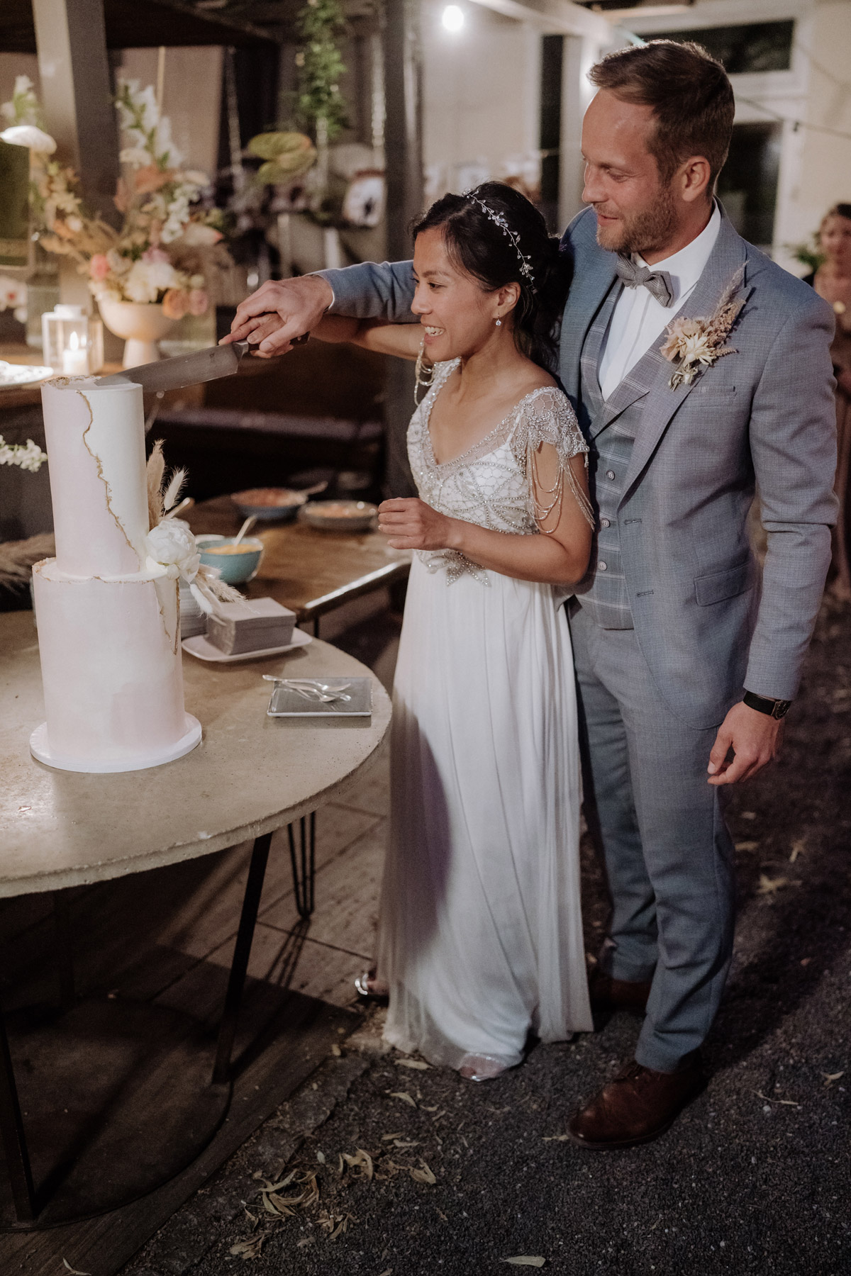 Brautpaar schneidet Hochzeitstorte an im Hinterhof vom heimlichTreu Berlin