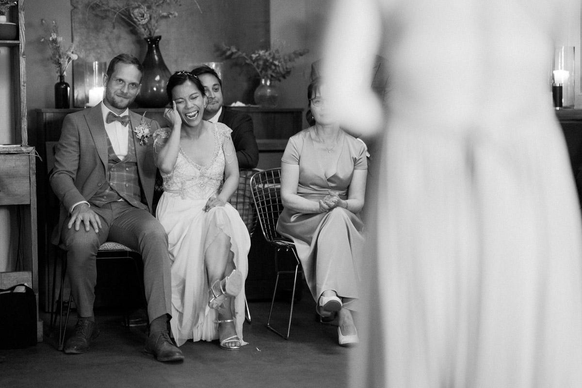 Hochzeitspaar lacht zum Auftritt der Gäste