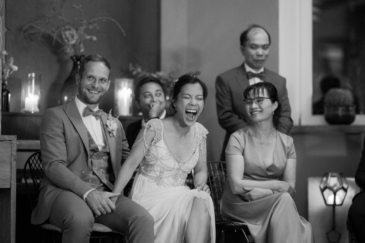 Brautpaar lacht über Aufführung der Gäste im heimlichTreu Festsaal