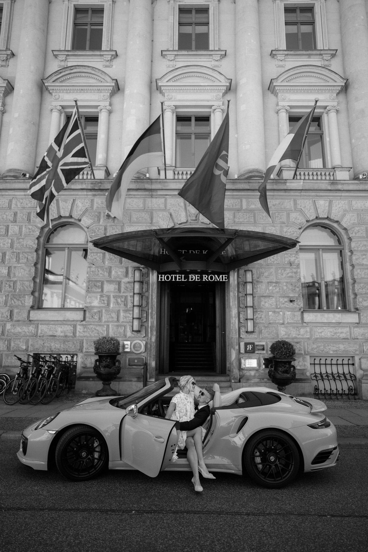 Brautpaar sitzt im Hochzeitsauto vor dem Hotel de Rome in Berlin kurz vor der Abfahrt zum Standesamt