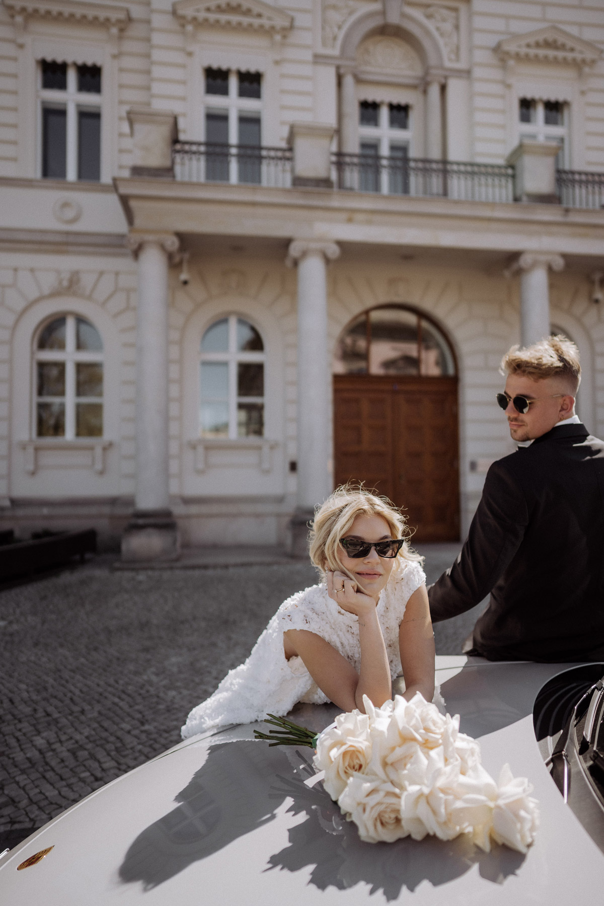 Hochzeitspaar schaut lässig und selbstbewusst zur Hochzeitsfotografin in die Kamera