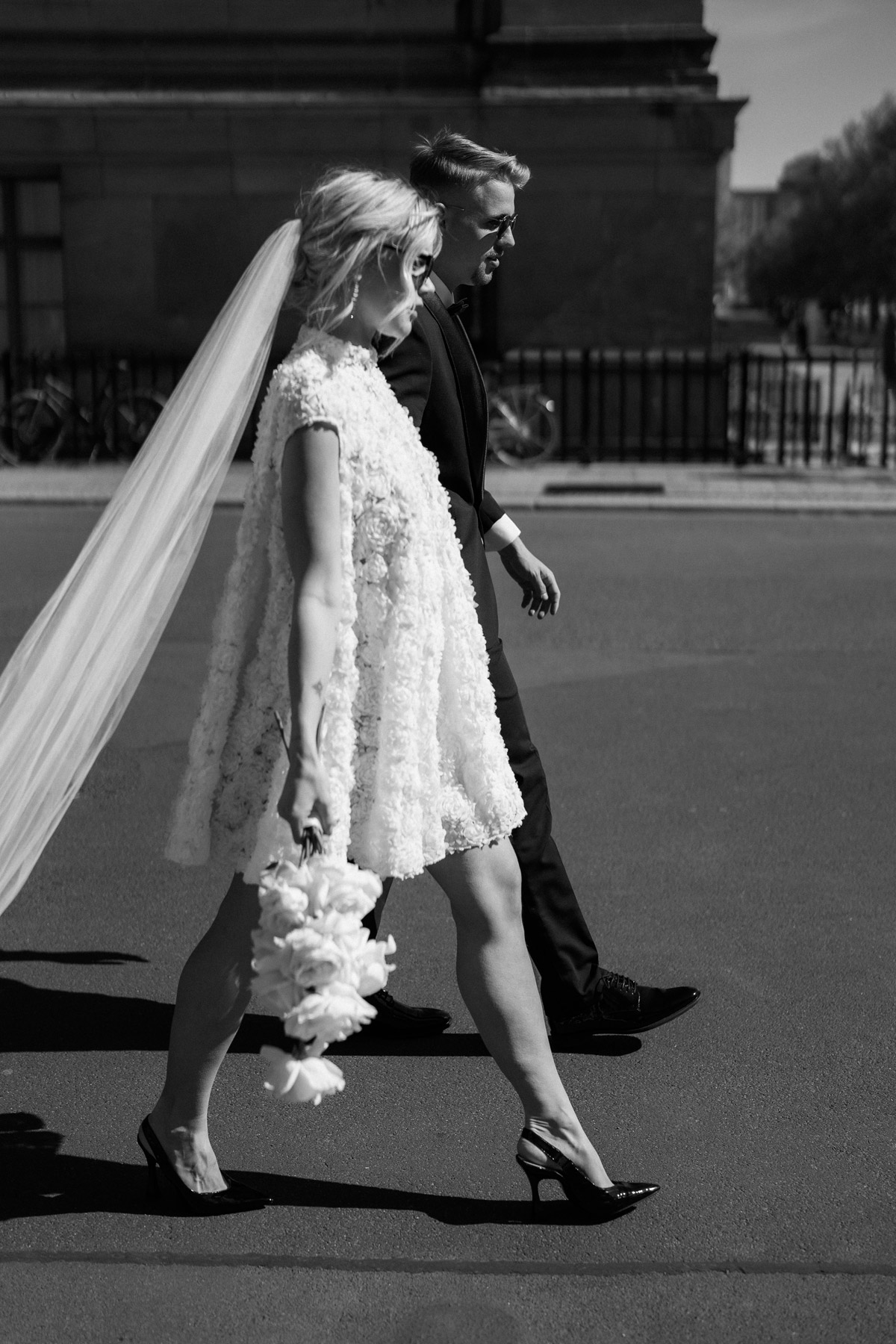 Brautpaar seitlich zu sehen geht die Straße entlang