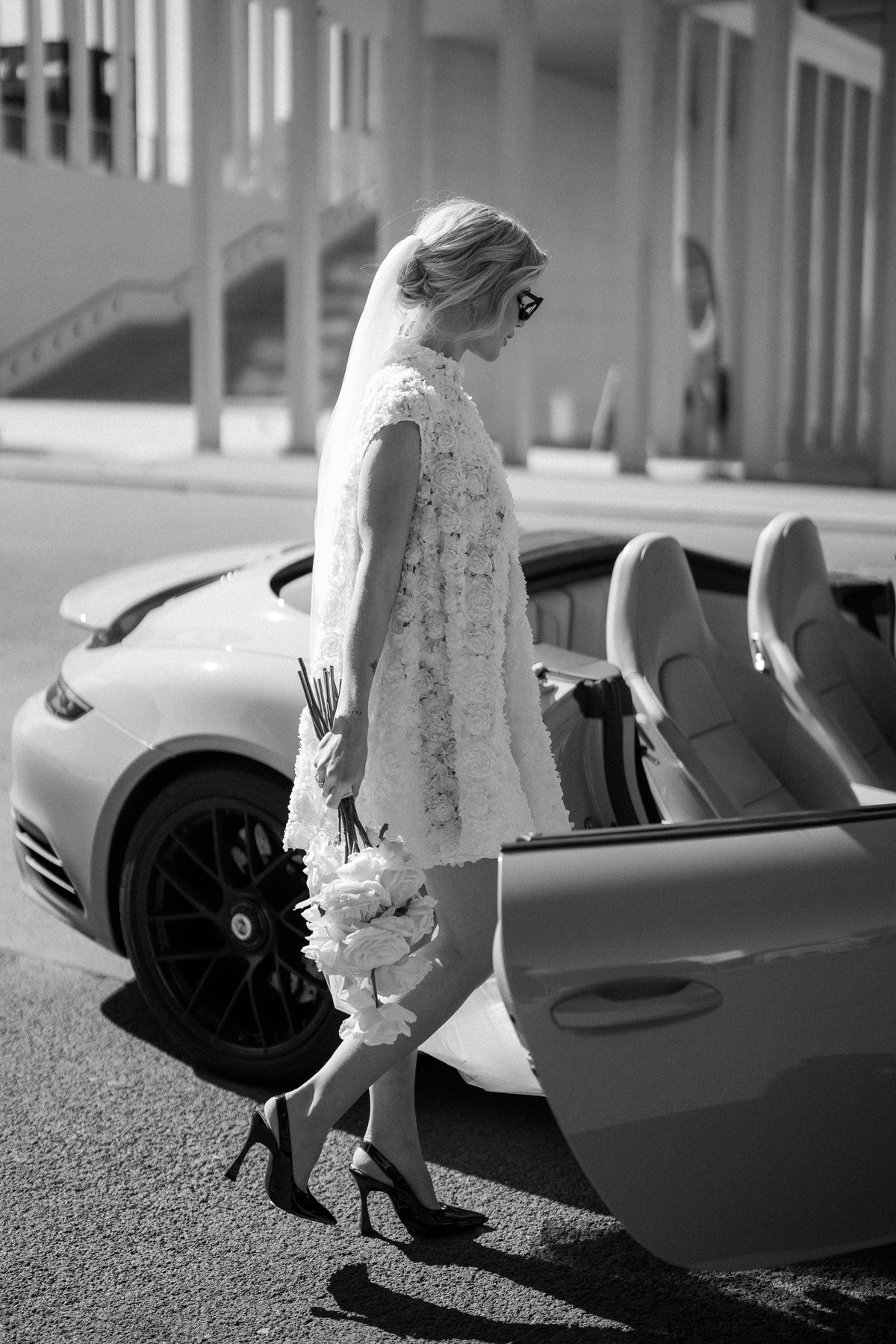 Urbane Braut im Standesamtkleid steigt während Fotoshooting in Porsche Cabrio - Berlin Mitte Vanity Fair Look