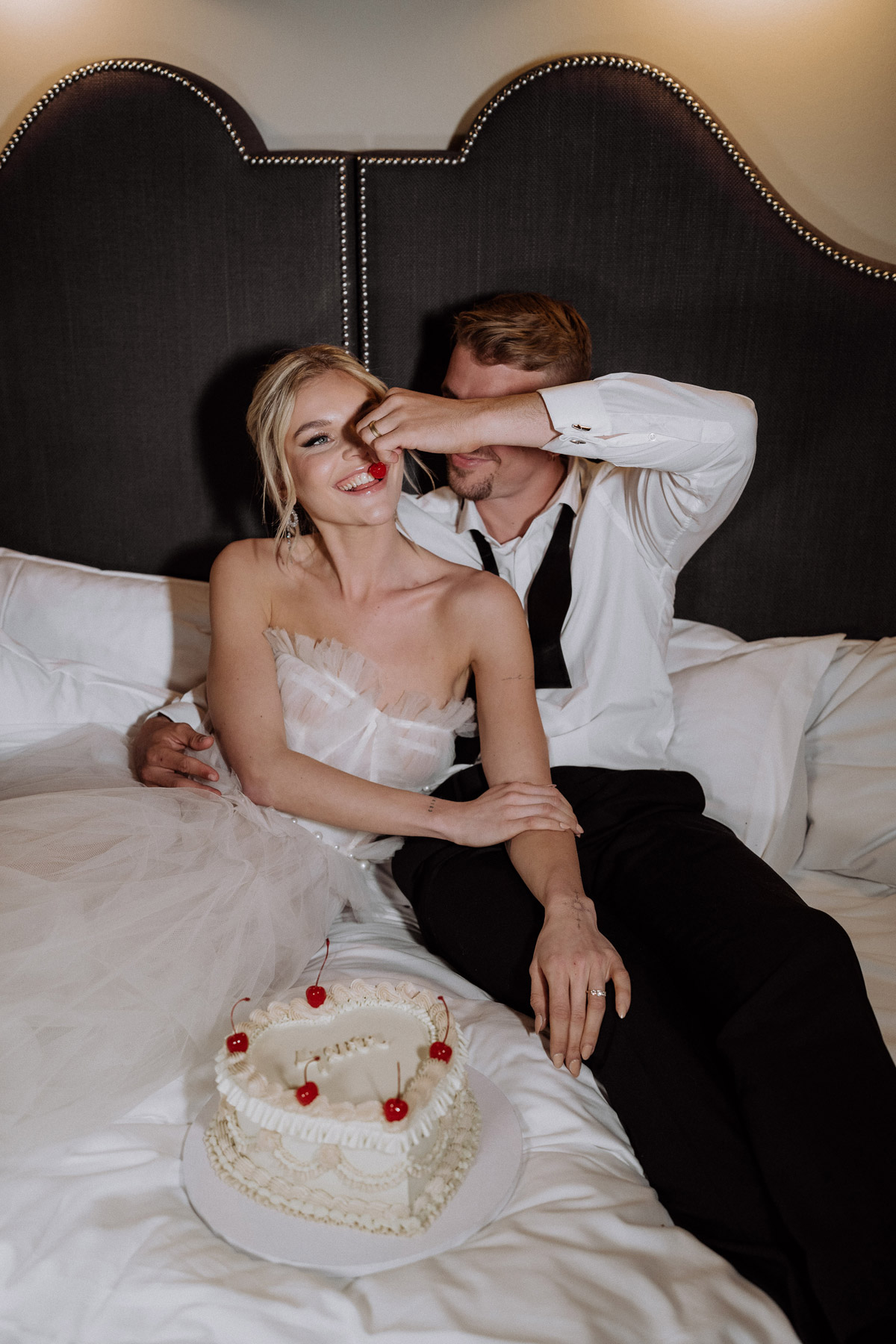 Candid Moments: Elopement Brautpaar füttert sich mit Torte und lacht