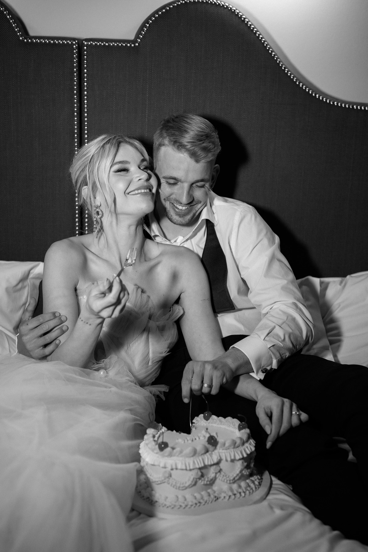 Direct Flash Photography: Modernes Hochzeitsfoto mit Blitzlicht auf das lachende Paar im Bett