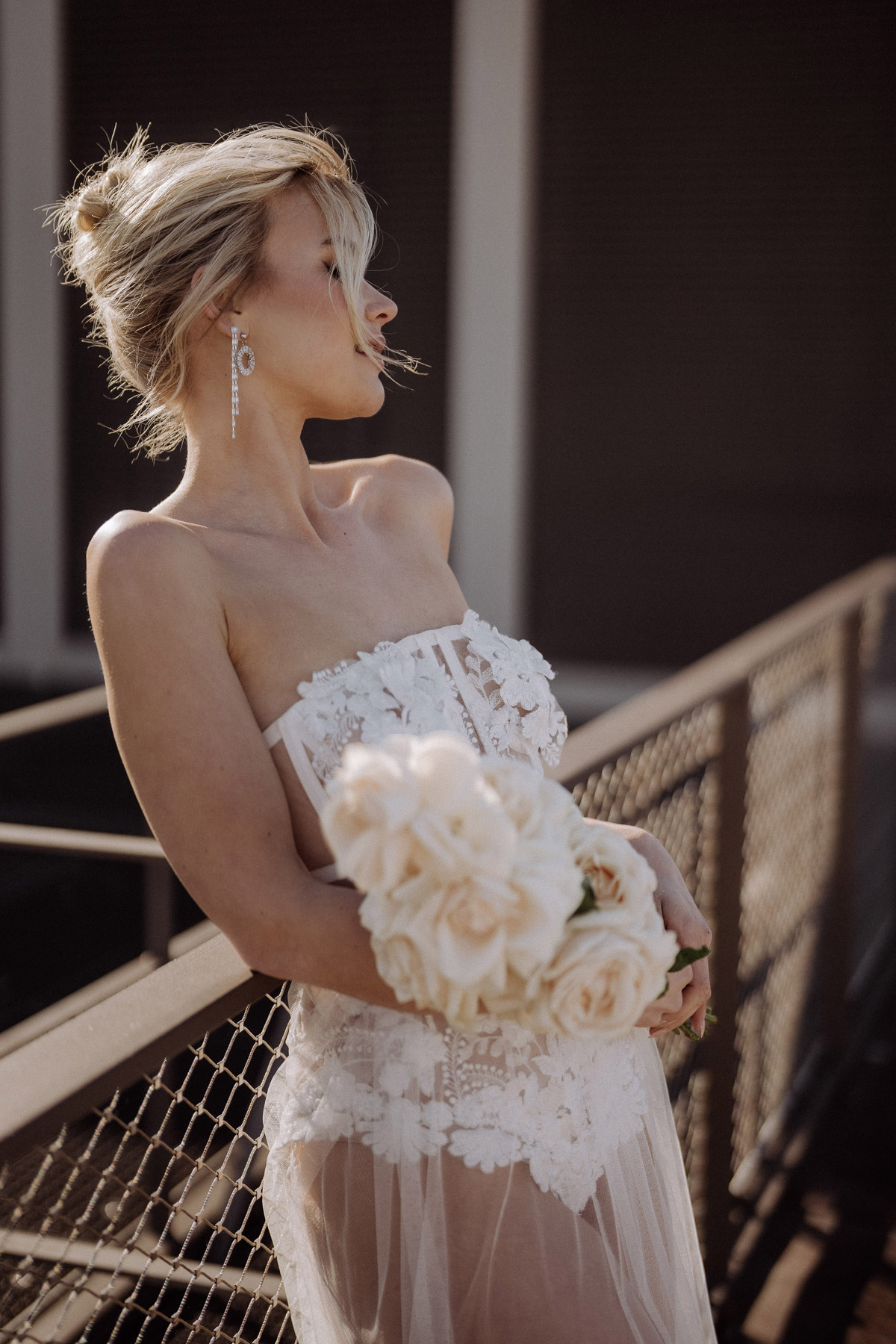 Braut steht am Geländer ihrer Rooftop Hochzeit