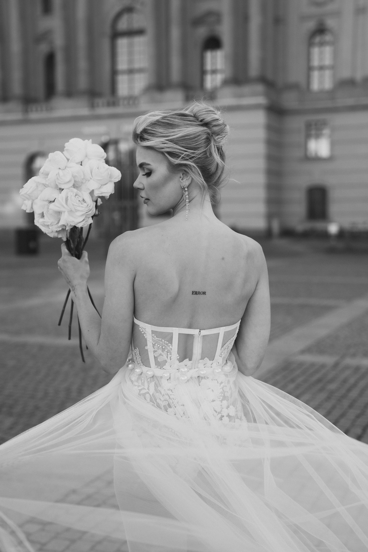 Braut von hinten verlässt das Berliner Schloss mit wehendem Brautkleid