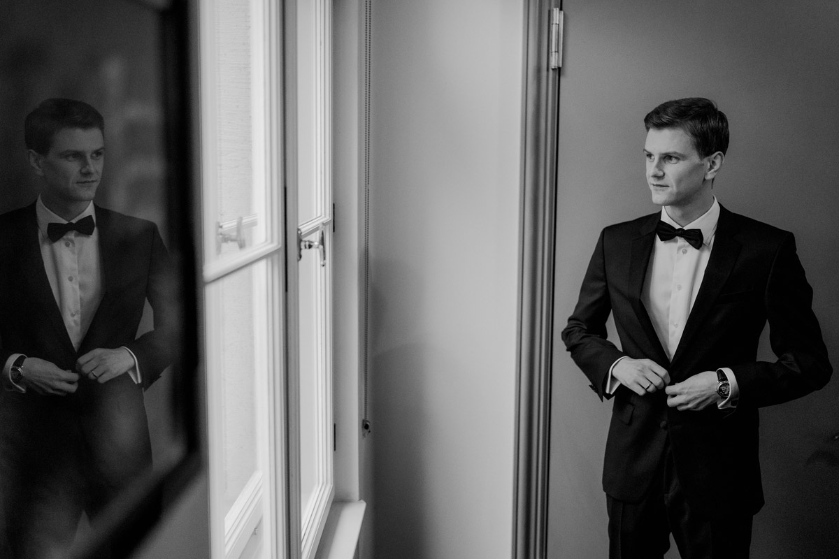 Bräutigam kleidet sich in der Suite des Schlosshotels Berlin an