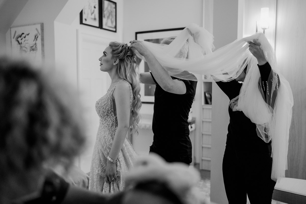 Braut bekommt Schleier ins Haar gesteckt