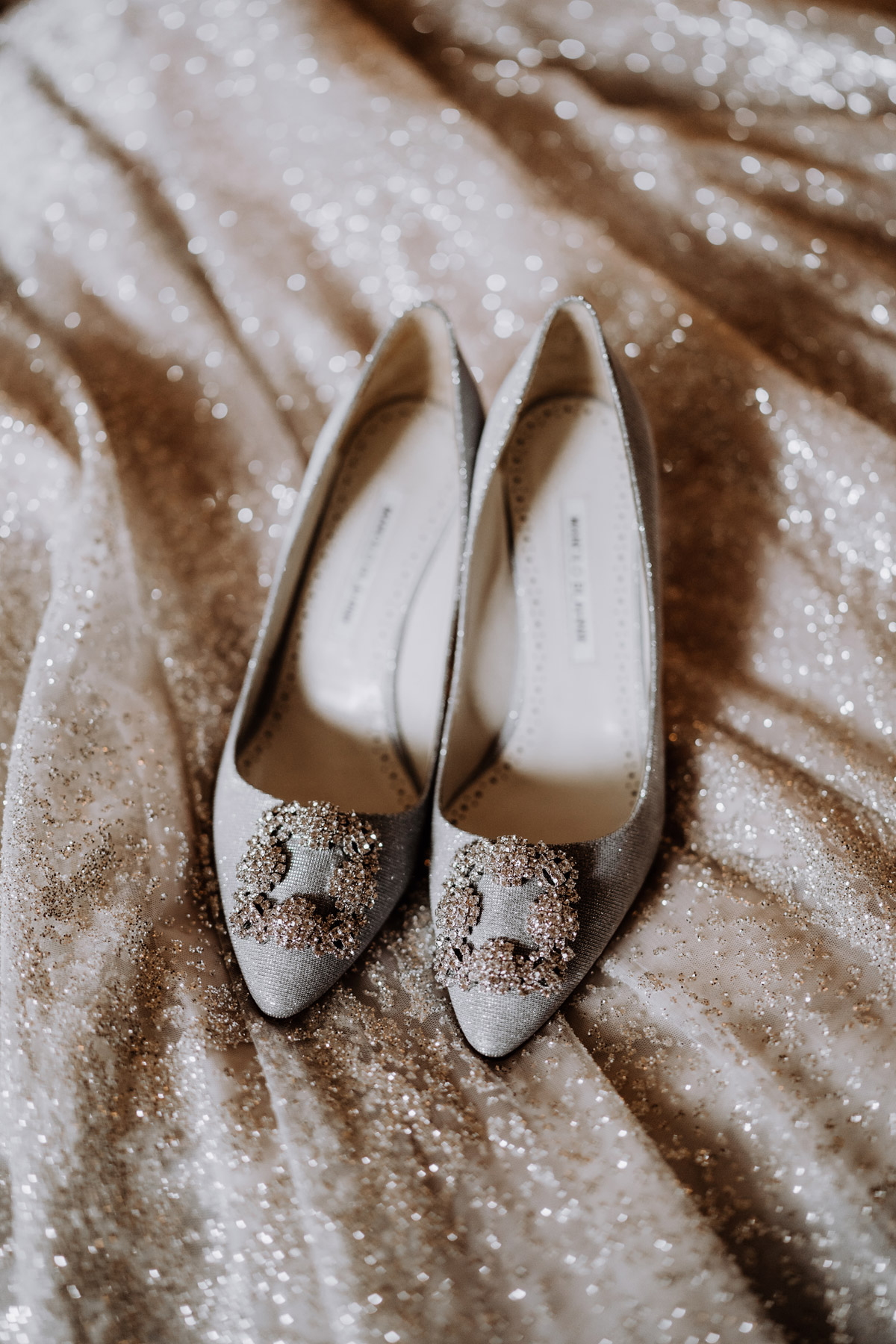 Brautschuhe liegen auf Hochzeitskleid