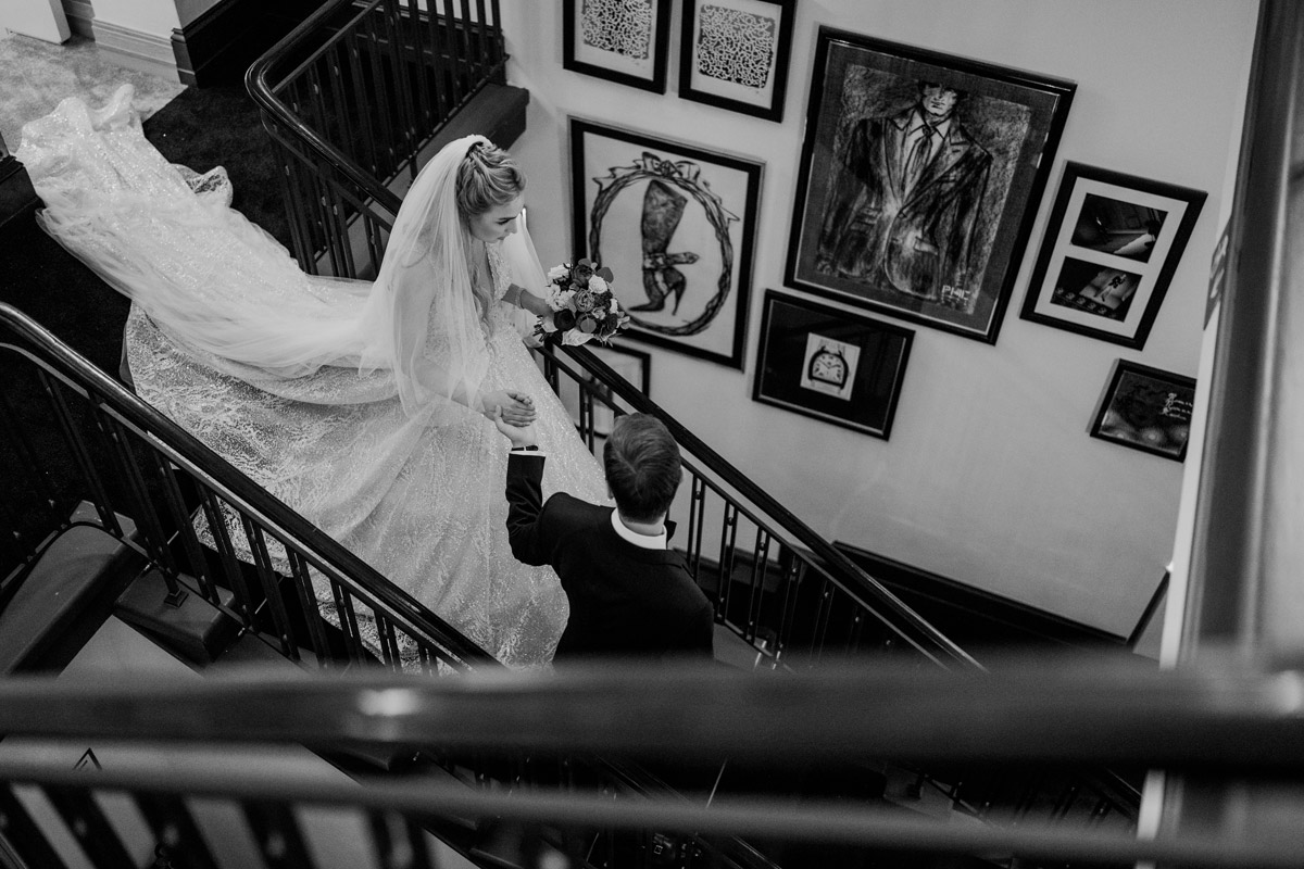 Bräutigam hilft Braut beim Treppe steigen