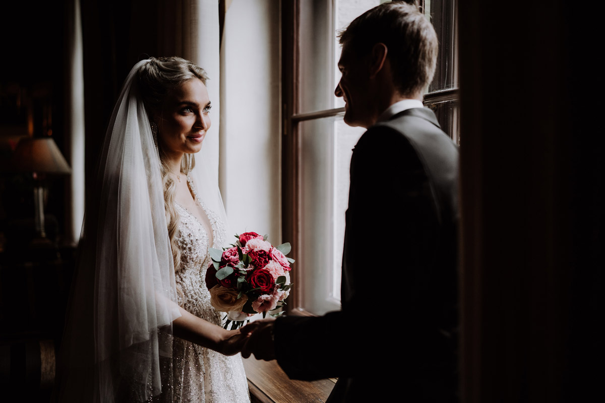Schlosshotel Berlin Hochzeit mit Regen am Fenster schaut Braut Bräutigam an