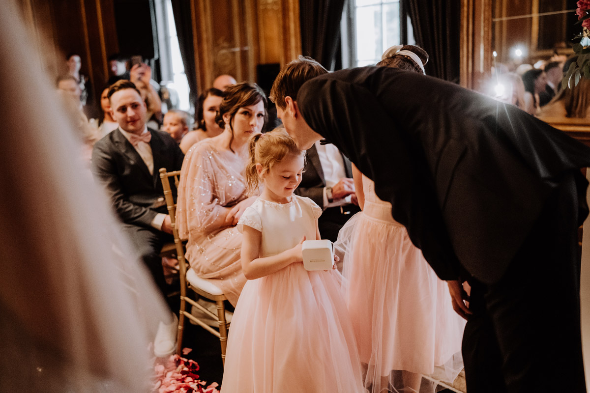 Bräutigam küsst Ringemädchen auf Kopf