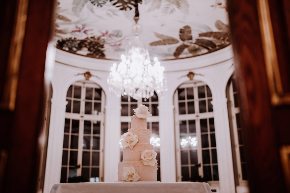 historischer Wintergarten Patrick Hellmann Schlosshotel Grunewald mit rosa Hochzeitstorte