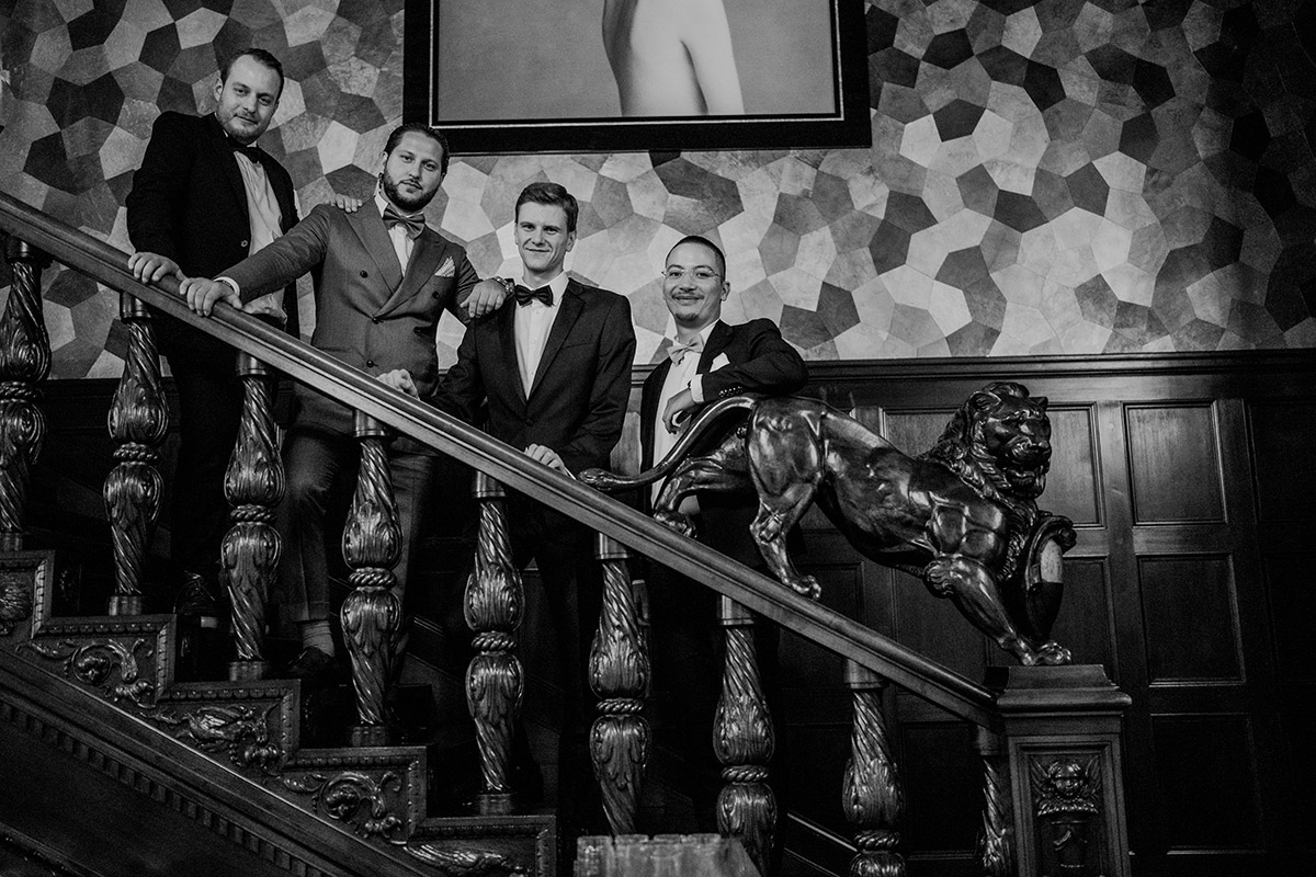 Gruppenfoto: Bräutigam steht mit Freunden auf der Lobbytreppe