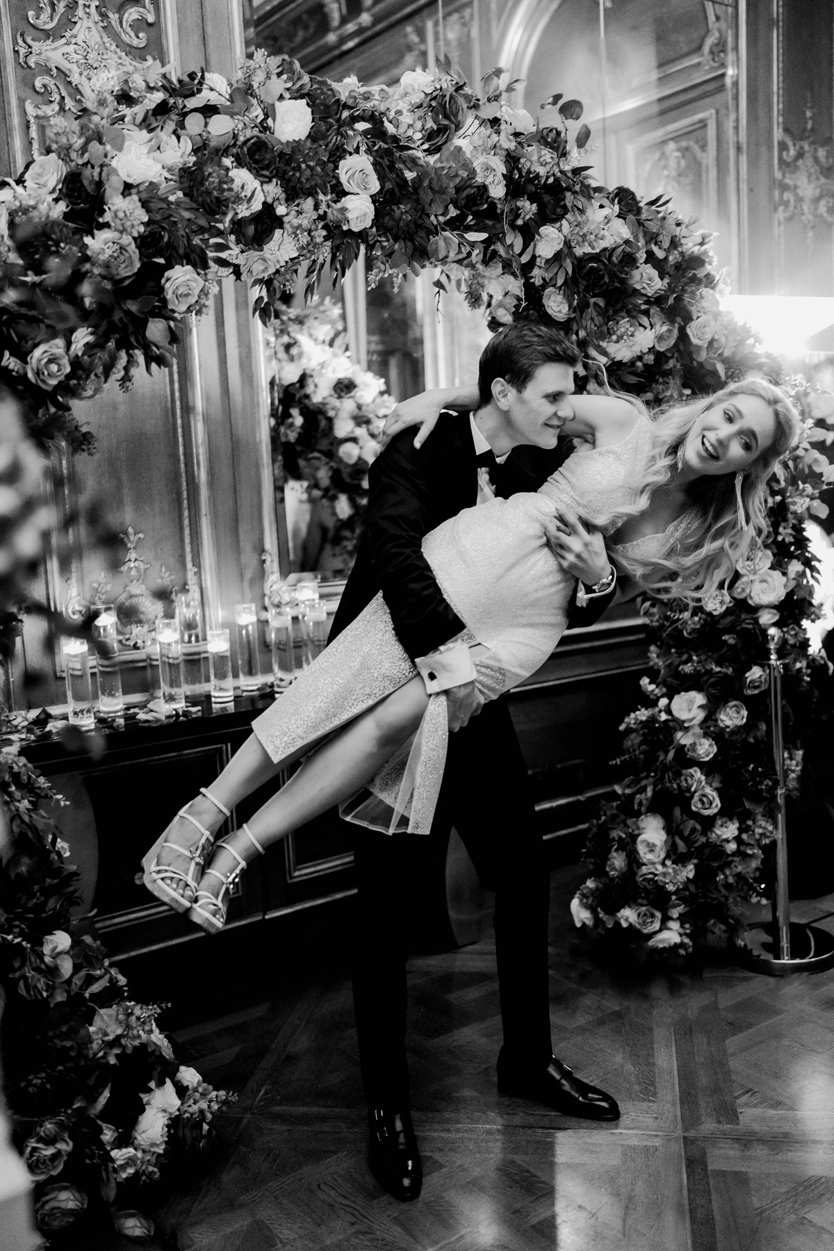 Bräutigam wirbelt Braut bei Hochzeitsparty im Schlosshotel in Schwarz-Weiß
