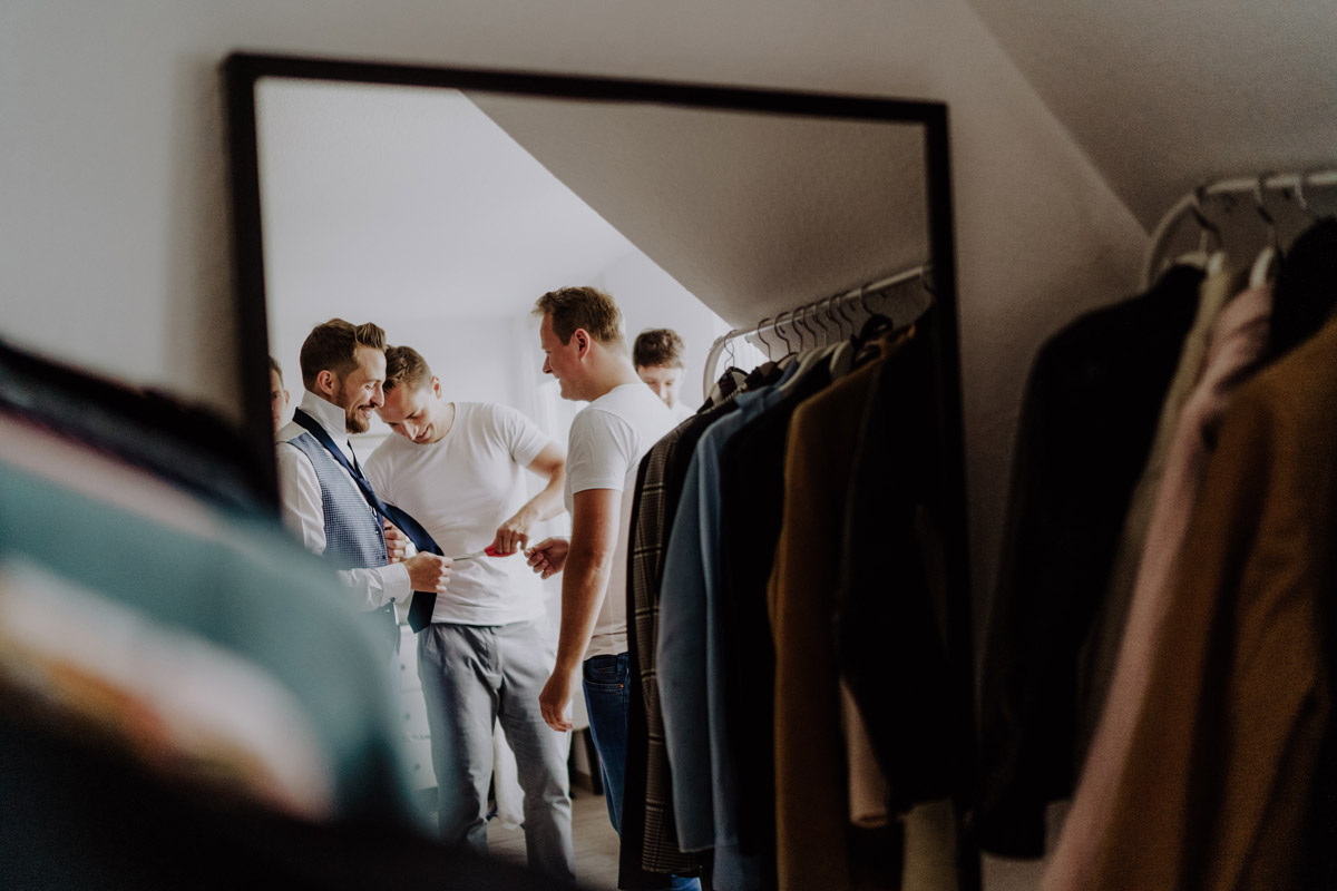 Trauzeuge unterstützt Bräutigam beim Ankleiden