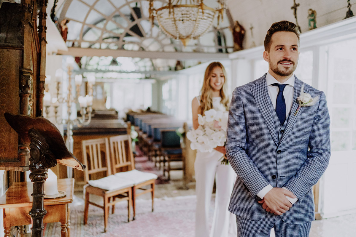 Braut tippt Bräutigam beim First Look auf die Schulter