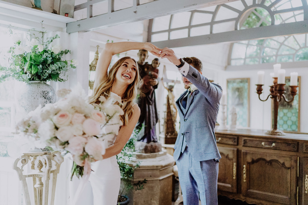 Standesamt Fotograf Berlin: Glücklicher Bräutigam dreht seine Braut beim privaten First Look vor der Trauung schwungvoll im Kreis. Ein entspannter Moment, der auch bei einer Regen-Hochzeit für magische, ungestörte Bilder sorgt.