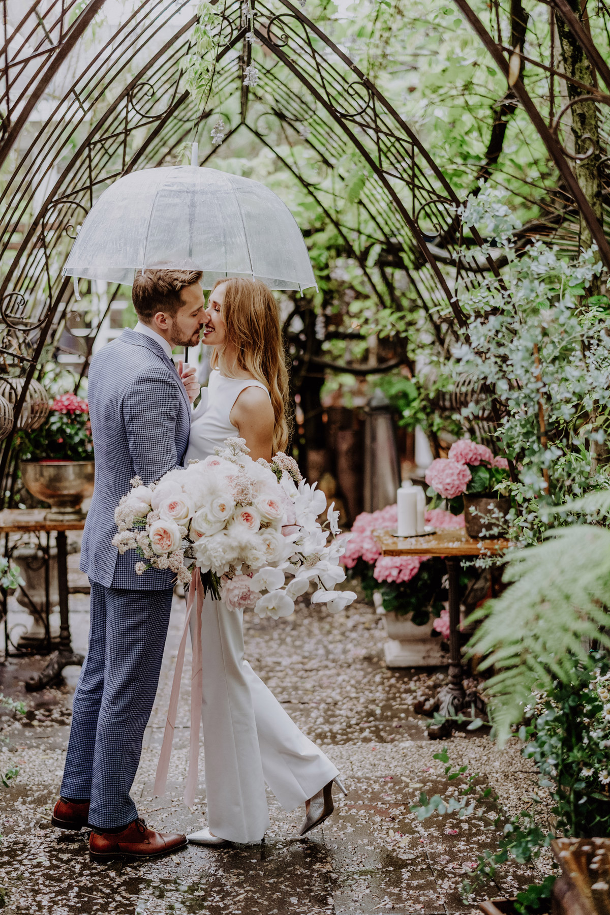 Regen Hochzeit Berlin: Brautpaar unter transparentem Regenschirm