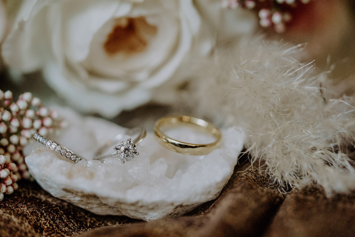 Eheringe Hochzeitsfoto Idee: Ringe auf glitzernden Stein vor Brautstrauß