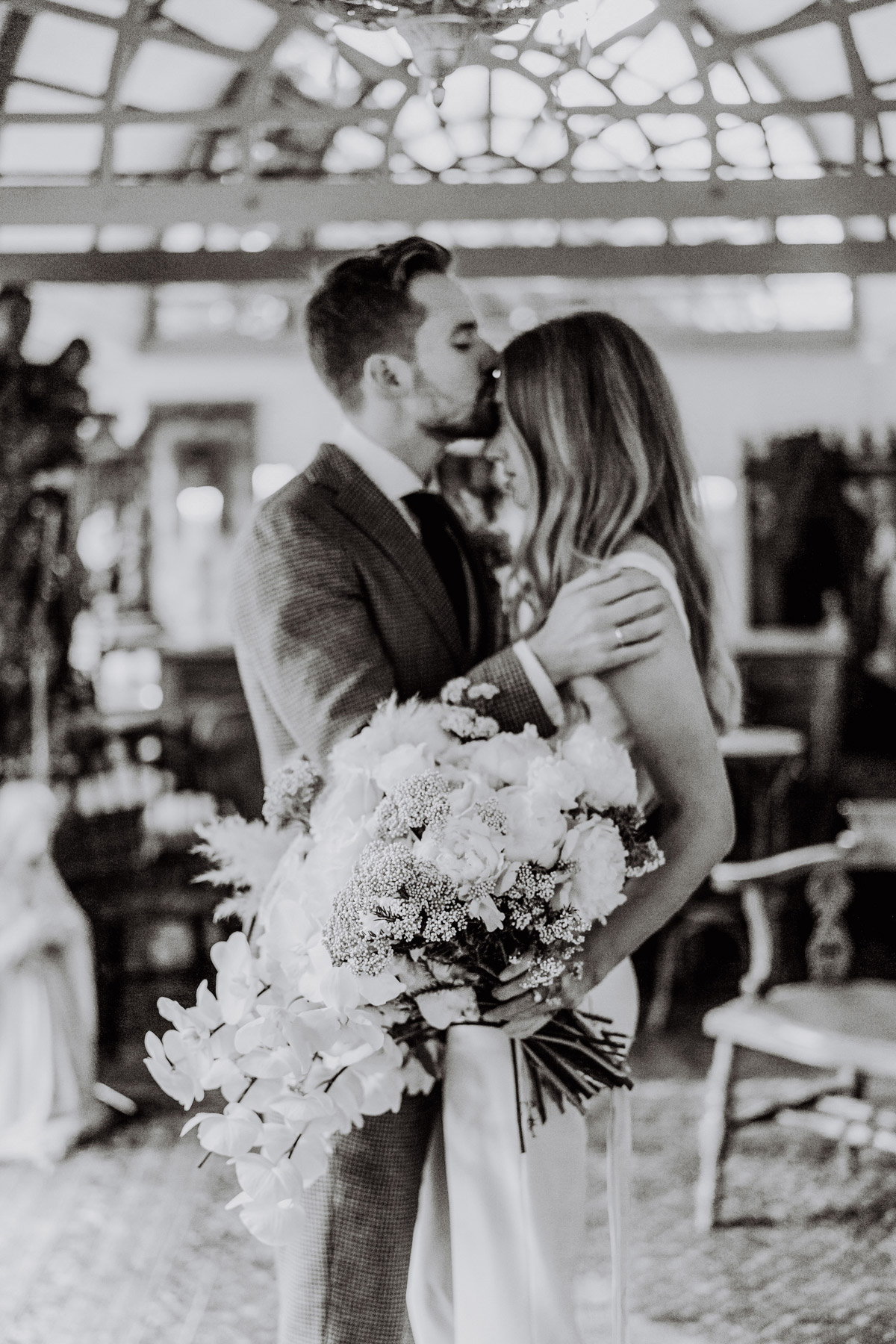 Editorial Brautpaarfoto vom Standesamt Brautstrauß mit unscharfem Paar im Hintergrund in Sepia