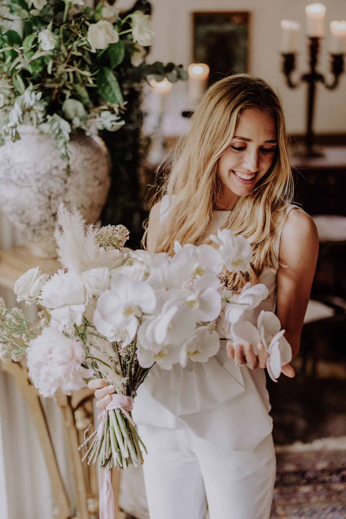 Braut schaut leicht seitlich auf Brautstrauß: Modernes Styling mit offenen Haaren